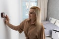 Close Up Of Woman Adjusting Central Heating Temperature At Home On Thermostat. Royalty Free Stock Photo