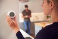 Close Up Of Woman Adjusting Wall Mounted Digital Central Heating Thermostat Control At Home Royalty Free Stock Photo