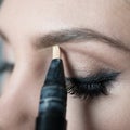 Close Up of Woman Applying Make Up Along Brow Line