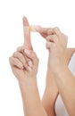 Close up of woman applying plaster on finger