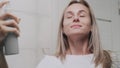 Close up Woman applying water spray for skin hydration