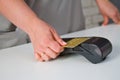 Close-up of a woman attaching a card to a credit card terminal to secure payment. Payment procedure Royalty Free Stock Photo