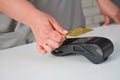 Close-up of a woman attaching a card to a credit card terminal to secure payment. Payment procedure Royalty Free Stock Photo