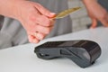 Close-up of a woman attaching a card to a credit card terminal to secure payment. Payment procedure Royalty Free Stock Photo