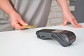 Close-up of a woman attaching a card to a credit card terminal to secure payment. Payment procedure Royalty Free Stock Photo