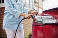 Close Up Of Woman Attaching Charging Cable To Environmentally Friendly Zero Emission Electric Car At Home Royalty Free Stock Photo