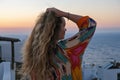 Close up of woman from back with hand in hair watching sunset and sea view from terrace of luxury holiday villa Royalty Free Stock Photo