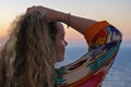 Close up of woman from back with hand in hair watching sunset and sea view from terrace of luxury holiday villa Royalty Free Stock Photo