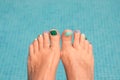 Close up on woman bare feet, blue water Royalty Free Stock Photo