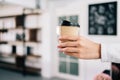 Close up woman barista hand serving coffee paper disposable cup in the coffee shop. Owner and employee service for the client