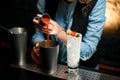 Close-up. Woman bartender gently pours drink from jigger into metal glass Royalty Free Stock Photo