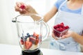 Close up of woman with blender making fruit shake Royalty Free Stock Photo