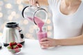 Close up of woman with blender pouring milk shake