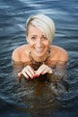 Close-up of a woman blonde middle-aged nude swims in the river, selective focus Royalty Free Stock Photo