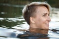 Close-up of a woman blonde middle-aged nude swims in the river, selective focus Royalty Free Stock Photo