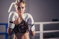 Female Boxer wearing gloves posing in boxing studio