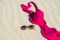 Close up of woman bra and glasses on the sand. Concept of sunbathing naked on the nude beach. Naturalist lifestyle. Nobody