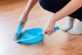 Close up of woman with brush and dustpan sweeping