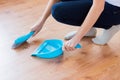 Close up of woman with brush and dustpan sweeping