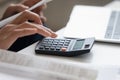 Close up of woman calculate finances expenses on machine