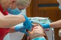 Close-up woman with ceramic braces on teeth at the dental office. Dentist holding dental tool - corner ligature cutters. Orthodont