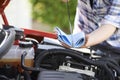 Close-Up Of Woman Checking Car Engine Oil Level On Dipstick