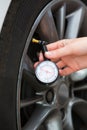 Close-Up Of Woman Checking Car Tyre Pressure With Gauge Royalty Free Stock Photo
