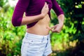 Close up woman checks and pinching Excess fat on her stomach see Royalty Free Stock Photo