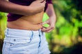 Close up woman checks and pinching Excess fat on her stomach see Royalty Free Stock Photo