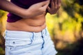 Close up woman checks and pinching Excess fat on her stomach see Royalty Free Stock Photo