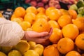 Close-up, woman choosing orange at the grocery store. Royalty Free Stock Photo