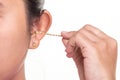 Close up woman cleaning her ear by using metal stick isolated on Royalty Free Stock Photo