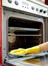 Close up of woman cleaning oven at home kitchen