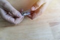 Close-up of woman clipping her nails with nail clippers, after cutting short nails, dark, rough skin Royalty Free Stock Photo