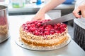 Close-up of woman confectioner cutting raspberry pie