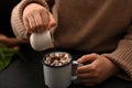 Close-up, A woman pouring a chocolate syrup on a hot chocolate with marshmallow Royalty Free Stock Photo