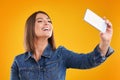 Close up of woman in denim jacket with smartphone over yellow background Royalty Free Stock Photo