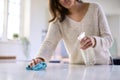 Close Up Of Woman Doing Chores In Kitchen At Home Cleaning And Disinfecting Surface With Spray