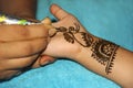 Close-up of woman drawing mehendi or tattoo on little girl`s palm Royalty Free Stock Photo