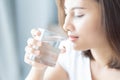 Close up woman drinking pure water from glass with light in the morning, Selective focus Royalty Free Stock Photo