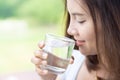 Close up woman drinking pure water from glass with light in the morning, Selective focus Royalty Free Stock Photo