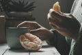 Close up of woman eating orange fruit and drinking herbal tea or coffee at home. healthy food and beverage lifestyle people indoor Royalty Free Stock Photo