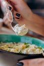 Close up of woman eating tasty Mussels in cheese sauce with dumplings served with greens Royalty Free Stock Photo