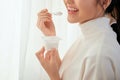 Close up woman eating yogurt behind the window Royalty Free Stock Photo