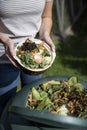 Close Up Of Woman Emptying Food Waste Into Garden Composter At Home Royalty Free Stock Photo