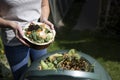 Close Up Of Woman Emptying Food Waste Into Garden Composter At Home Royalty Free Stock Photo