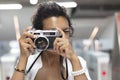 Close-up of a woman with exotic features taking a picture with an analog film camera