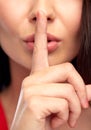 Close up of woman face holding finger on her lips Royalty Free Stock Photo