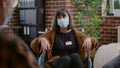 Close up of woman with face mask sitting in wheelchair at aa group meeting Royalty Free Stock Photo