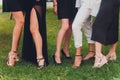 Close up of woman feet in summer sandals shoes walking on spring lawn covered with fresh green grass. Royalty Free Stock Photo